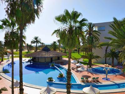 Großer Pool mit Schwimmbar, Palmen und Liegestühlen in sonniger Hotelanlage.