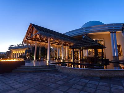 Luxusní hotelový vstup osvětlený za soumraku s moderním architektonickým designem.