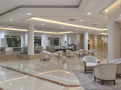 Ampia hall d'hotel con poltrone comode e luce calda.