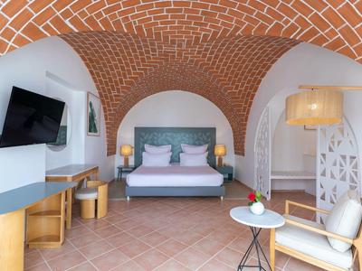 Camera d'hotel moderna con letto matrimoniale, muro in mattoni e decorazioni eleganti.