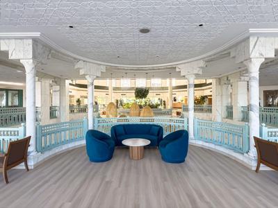 Elegant seating area with blue chairs and tables in a bright, open space.