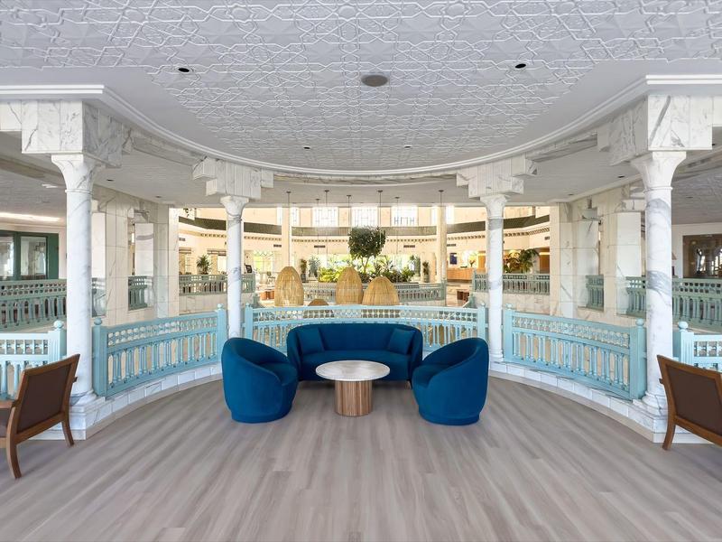 Elegant seating area with blue chairs and tables in a bright, open space.