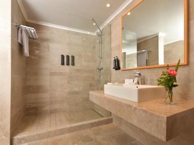 Modernes Badezimmer mit ebenerdiger Dusche, Waschbecken auf großem Waschbecken und Spiegel.