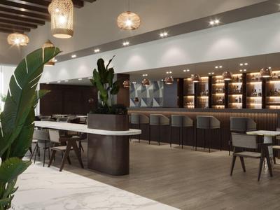 Area lounge d'hotel moderna con posti a sedere eleganti, piante e luce calda.