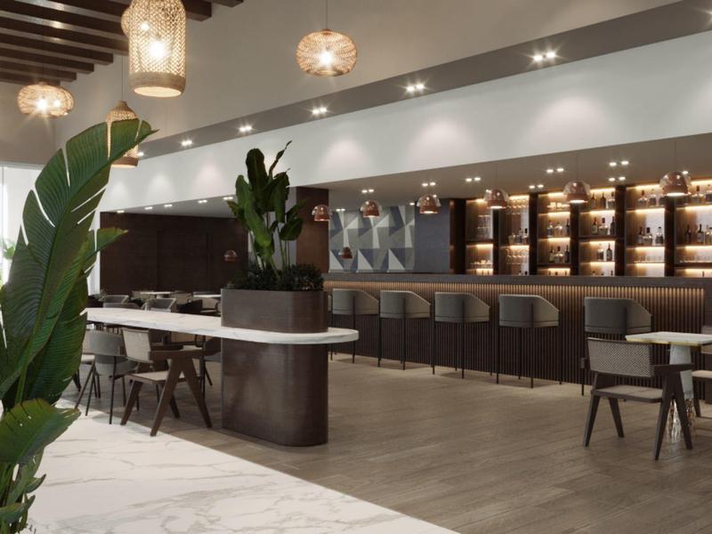 Area lounge d'hotel moderna con posti a sedere eleganti, piante e luce calda.