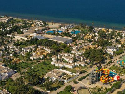 Vue aérienne d'une station balnéaire avec piscines, parc aquatique et accès direct à la plage.