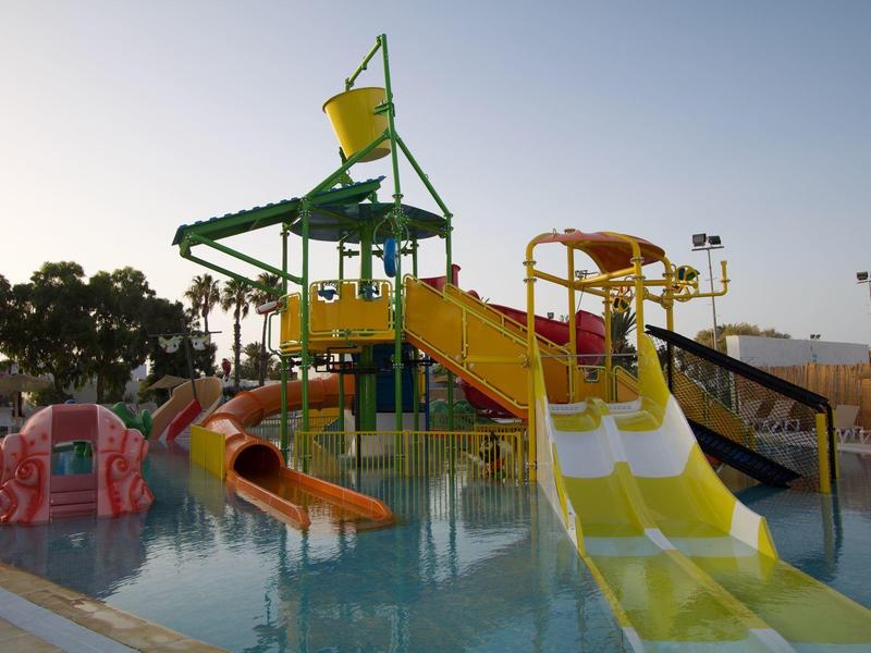 Parc aquatique avec toboggans colorés et jeux dans une piscine extérieure.