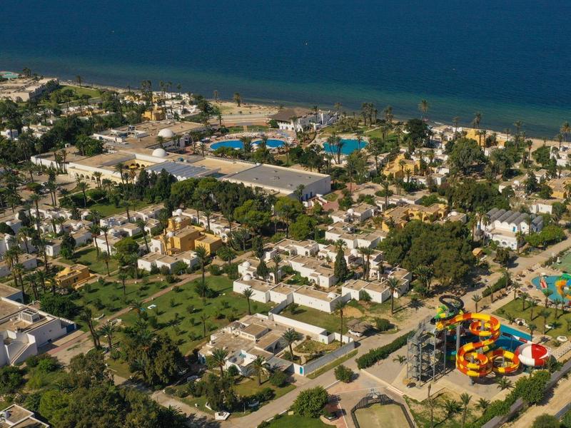 Vue aérienne d'une station balnéaire avec piscines, parc aquatique et accès direct à la plage.