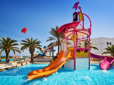 Parque acuático colorido con toboganes en la piscina del hotel en un día soleado.