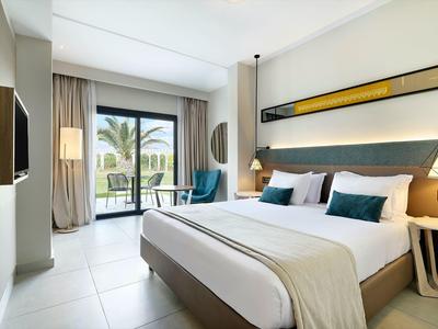 Modernes Schlafzimmer mit großem Bett, neutralen Farben, Balkon und Meerblick.