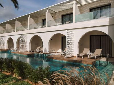 Modernes Gebäude mit Arkaden, privatem Pool und Liegestühlen in hellem Beigeton.