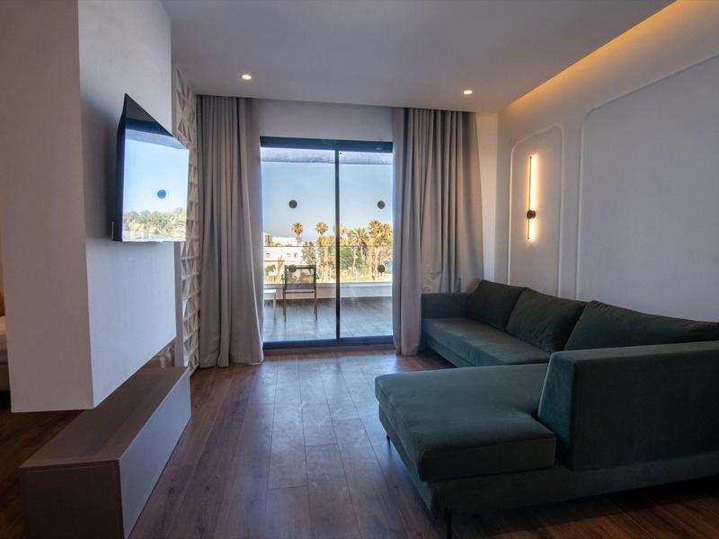 Sala de estar moderna con sofá grande y vista a un balcón con vista al mar.