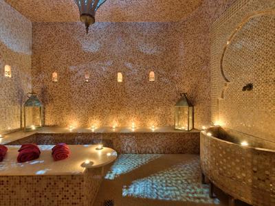 Ein warm beleuchteter Raum mit Mosaikfliesen und Kerzen, gemütlich und entspannend gestaltet.
