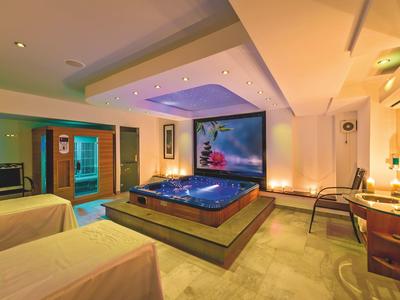 Moderne wellnessruimte met bubbelbad, massagetafels en sfeerverlichting.