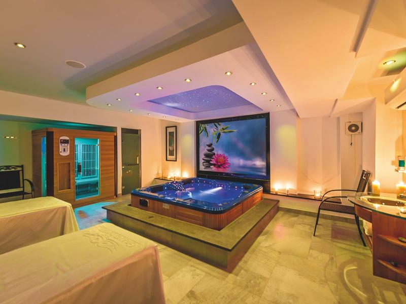 Moderne wellnessruimte met bubbelbad, massagetafels en sfeerverlichting.