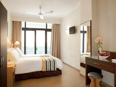 Modernes Hotelzimmer mit großem Bett, Schreibtisch und großer Fensterfront.