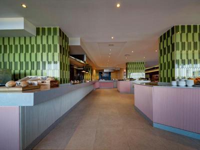 Moderner Frühstücksraum mit langen Buffets und warmem, indirektem Licht.