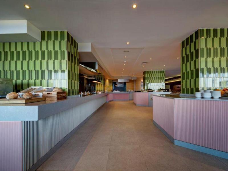 Moderner Frühstücksraum mit langen Buffets und warmem, indirektem Licht.