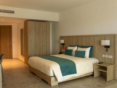 Modernes Hotelzimmer mit Doppelbett, Holzmöbeln und neutraler Farbgebung.