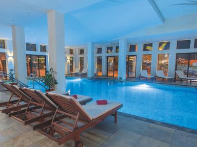 Kryty basen z podgrzewaną wodą i leżakami w hotelu.