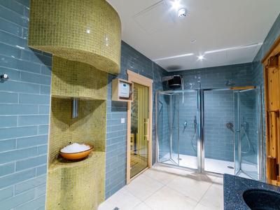 Nowoczesna strefa wellness z sauną, prysznicem i umywalką w hotelu.