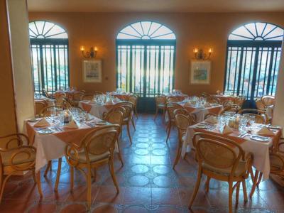 Ristorante elegante con sedie di legno curve e grandi finestre con vista esterna.