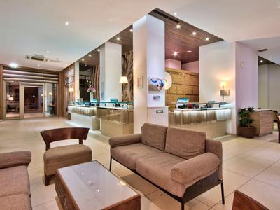 Moderner Hotel-Lobbybereich mit Sitzgelegenheiten und Rezeption im Hintergrund.