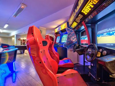 Spielbereich mit Rennsimulatoren und roten Rennsitzen in einem modernen Arcade-Setup.