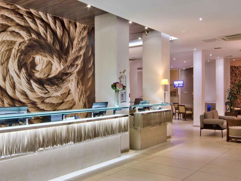 Moderner Hotel-Empfangsbereich mit hellem Tresen und stilvoller Holzdeko an der Wand