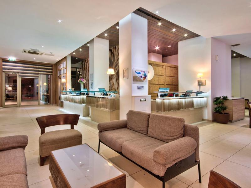 Moderner Hotel-Lobby-Bereich mit Sofas, Sesseln und einem Empfangstresen.