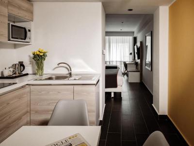 Moderner Küchenbereich mit Holzschränken und Blick in einen gemütlichen Wohnbereich.