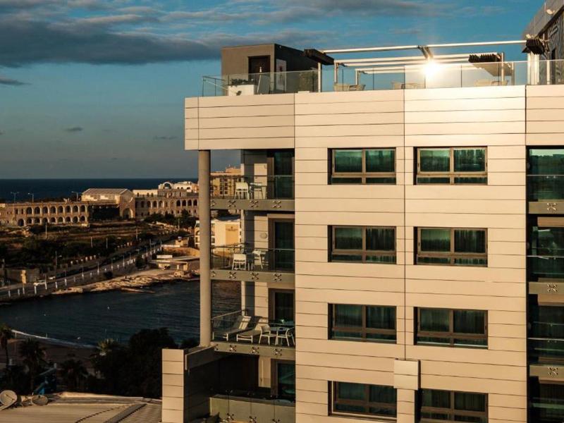 Moderner Hotelkomplex mit Meerblick bei Sonnenuntergang