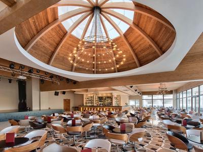 Velká hotelová barová část se stylovým dřevěným kopulovým stropem a spoustou sezení.