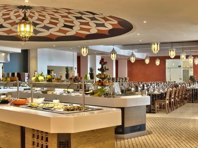 Bufetová část s různými jídly a stylovým posezením v restauraci.