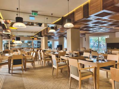 Moderní restaurace s dřevěným nábytkem a pohodlnými židlemi v hotelu.