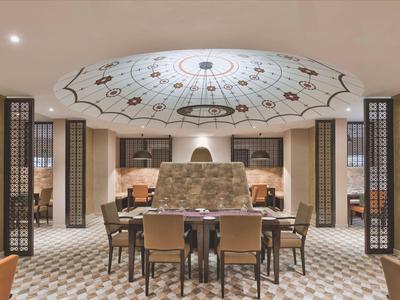 Modern hotel dining room with decorative ceiling centerpiece and stylish chairs