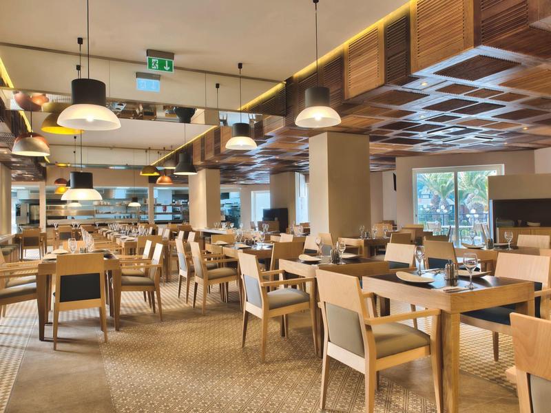 Moderní restaurace s dřevěným nábytkem a pohodlnými židlemi v hotelu.