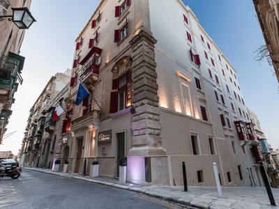 Bâtiment d'hôtel moderne dans une rue étroite avec des lignes épurées et de grandes fenêtres.