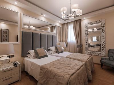 Nowoczesny pokój hotelowy z dwoma łóżkami, szafkami nocnymi i miejscem do siedzenia.