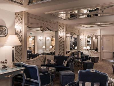 Intérieur d'hôtel élégant avec fauteuils confortables, canapés et éclairage raffiné.