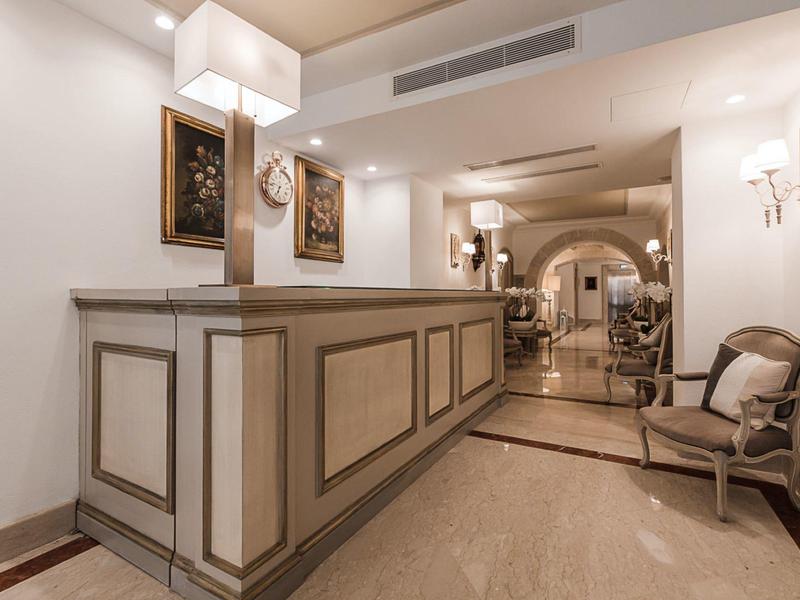 Elegancki hol hotelowy z klasycznym barem i antycznymi krzesłami.