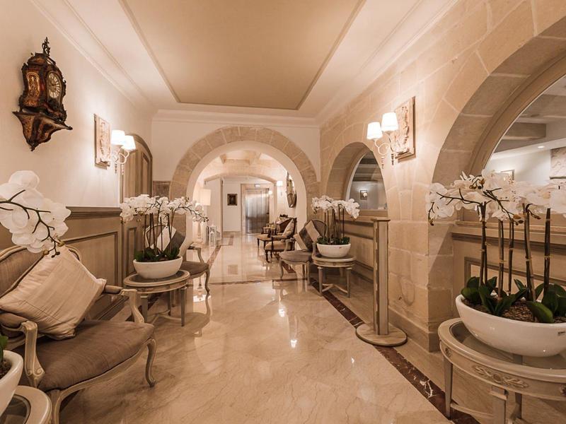 Elegancki hol hotelowy z wygodnymi fotelami, storczykami i ciepłym oświetleniem.