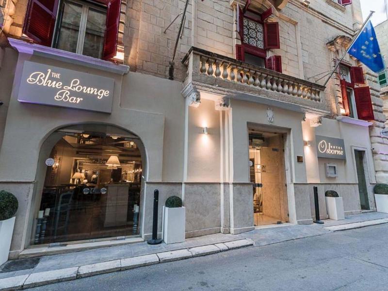 Elegancki bar z podświetlanym szyldem i ciepłym oświetleniem wnętrza na cichej ulicy.