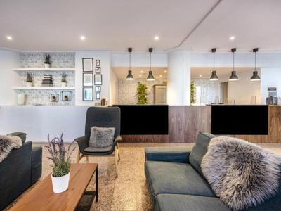 Moderner Hotellobby mit gemütlichen Sofas, Sesseln und dekorativen Pflanzen in hellem Ambiente