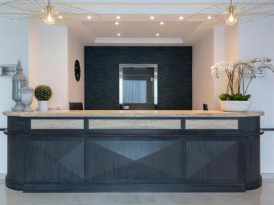 Moderní hotelová recepce se stylovým vybavením a rostlinami.