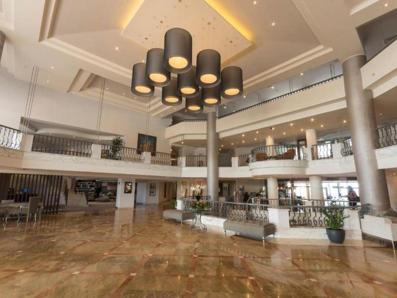 Velká moderní hotelová hala s posezením a velkými svítidly.