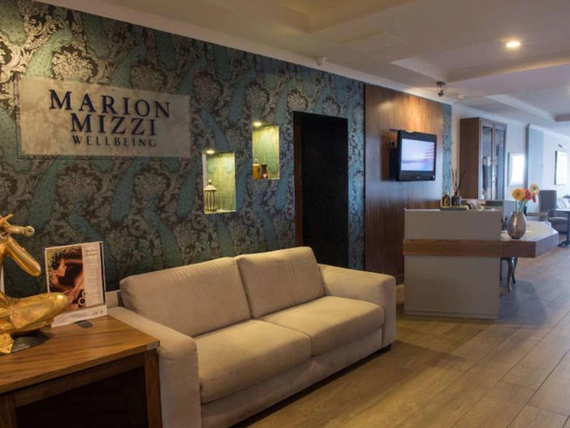 Pohodlný hotelový lounge s pohovkou a dekorativní stěnou.