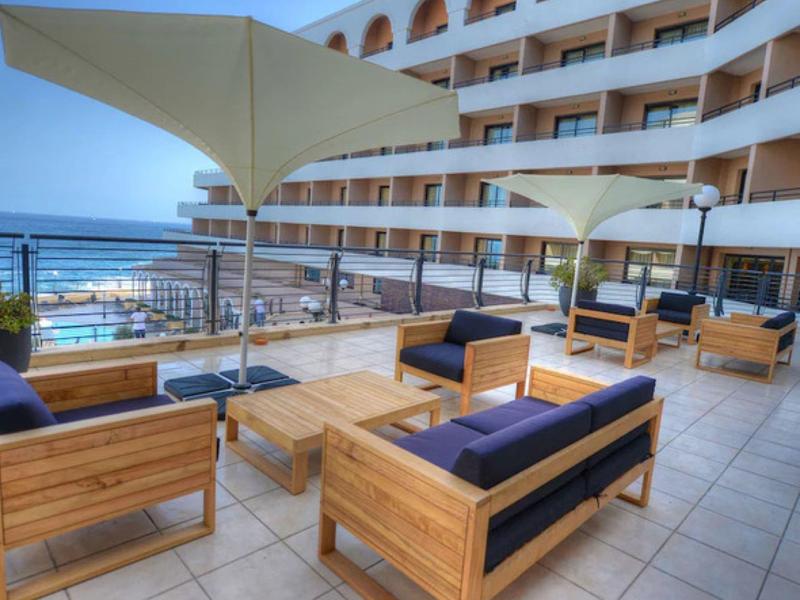 Moderní dřevěná terasa s slunečníky a výhledem na moře v hotelu