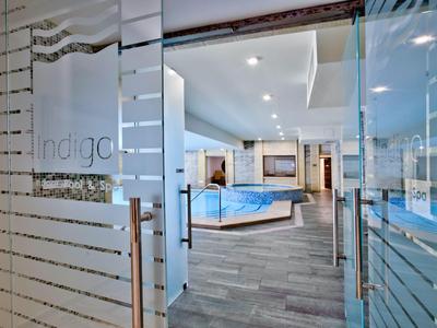 Moderner Wellnessbereich mit Whirlpool, Glaswänden und stilvollem Design in einem Hotel.