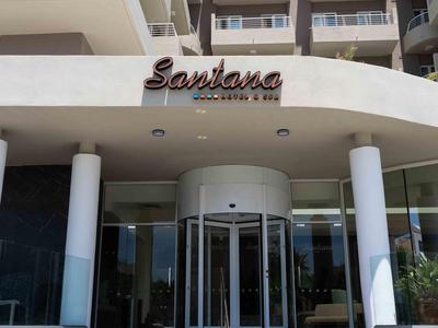 Eingang eines modernen Hotels mit Treppen, einem drehbaren Glastür und Balkonen darüber.